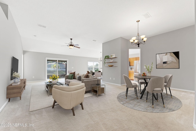 dining space featuring ceiling fan with notable chandelier, light colored carpet, visible vents, and baseboards