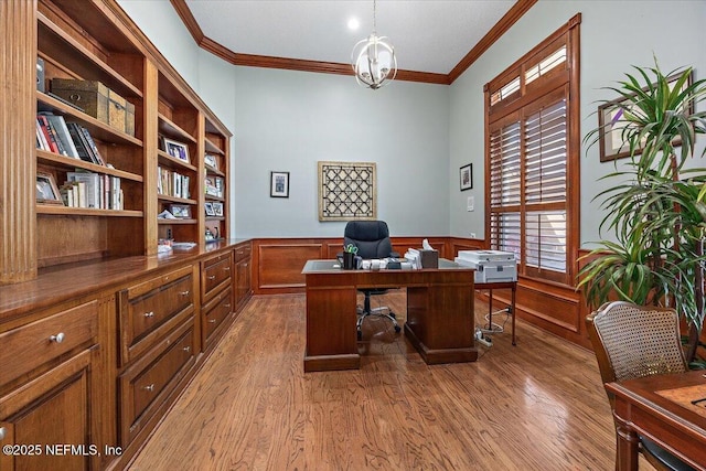 office space featuring a wainscoted wall, ornamental molding, and wood finished floors