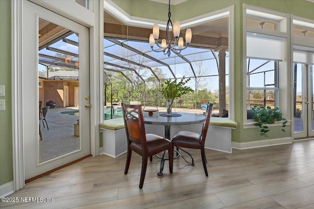 sunroom / solarium featuring a notable chandelier