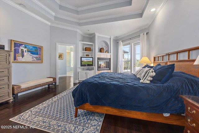 bedroom featuring a tray ceiling, dark wood-style flooring, and crown molding