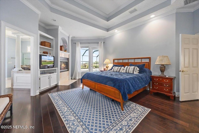 bedroom with visible vents, hardwood / wood-style floors, and crown molding