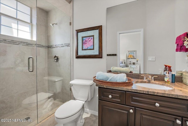 bathroom featuring vanity, toilet, and a shower stall