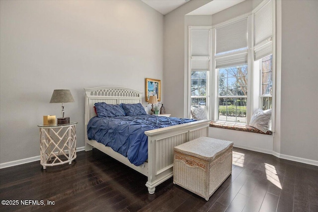 bedroom with dark wood finished floors and baseboards