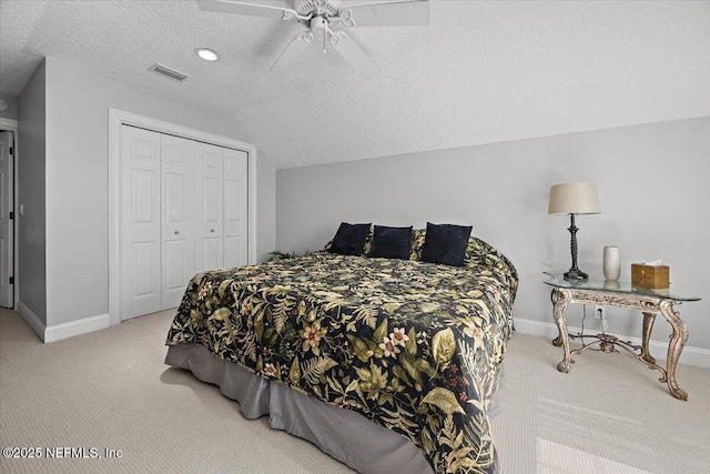 carpeted bedroom with baseboards, ceiling fan, lofted ceiling, a closet, and a textured ceiling