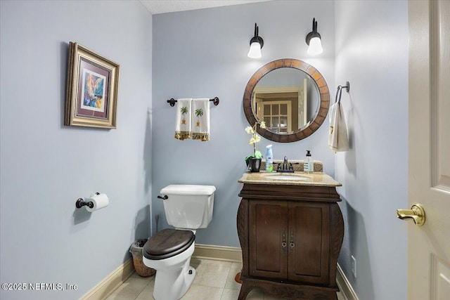 half bathroom with tile patterned flooring, toilet, vanity, and baseboards