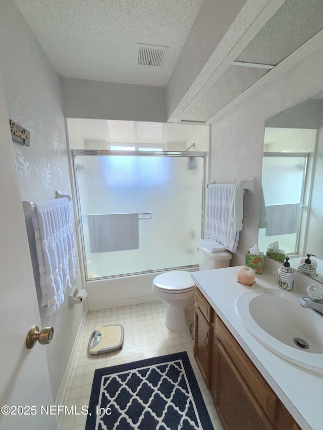 full bathroom featuring a textured ceiling, toilet, shower / bath combination with glass door, vanity, and visible vents