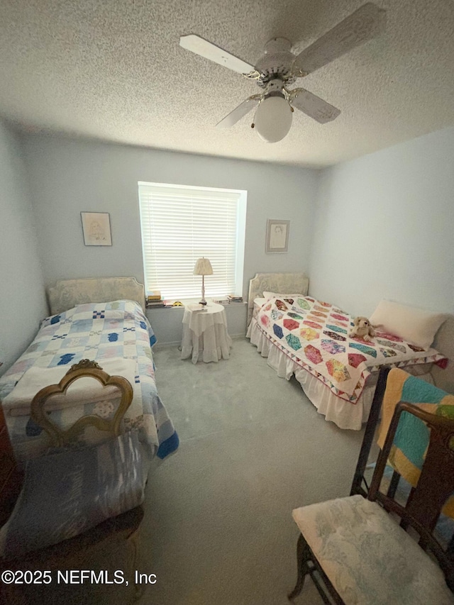 carpeted bedroom with a ceiling fan and a textured ceiling