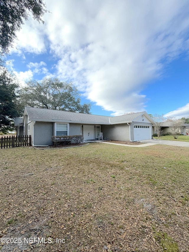 ranch-style home with a garage, a front yard, fence, and driveway