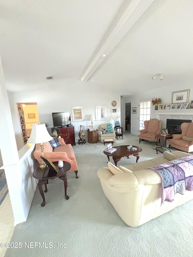 carpeted living room featuring a textured ceiling, beamed ceiling, a high end fireplace, and visible vents