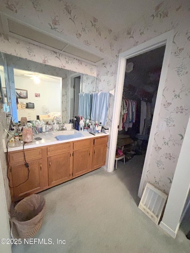 bathroom with vanity, visible vents, and wallpapered walls