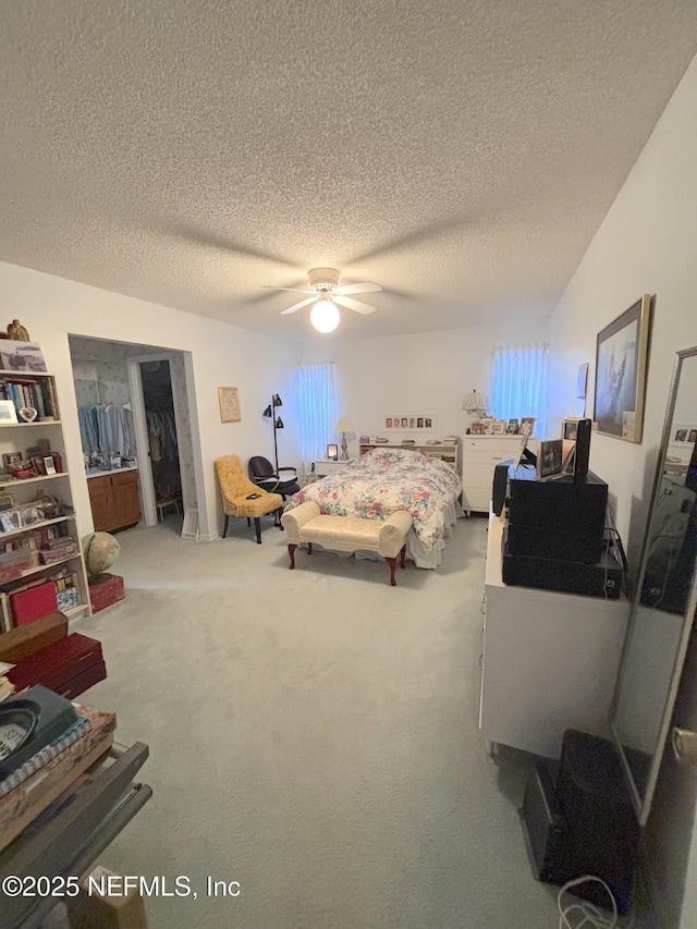 carpeted bedroom featuring a closet, a textured ceiling, and a ceiling fan