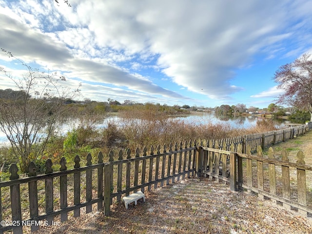 exterior space with a water view and fence