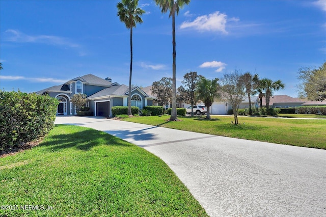 view of front facade featuring a front lawn, concrete driveway, and an attached garage