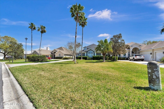 view of front of property with concrete driveway, a garage, a front lawn, and a residential view