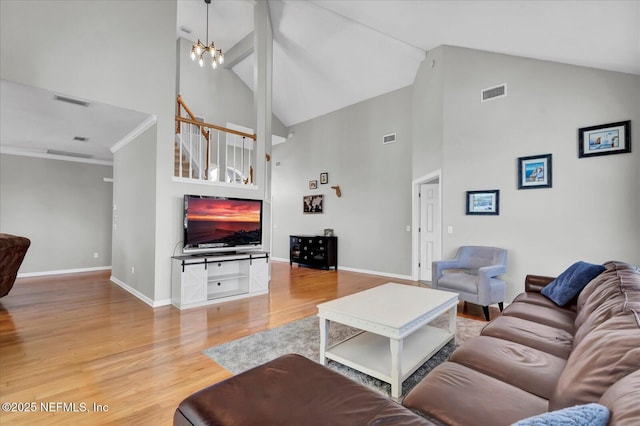 living room with visible vents, an inviting chandelier, baseboards, and wood finished floors