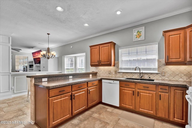 kitchen featuring a sink, backsplash, a peninsula, brown cabinetry, and dishwasher