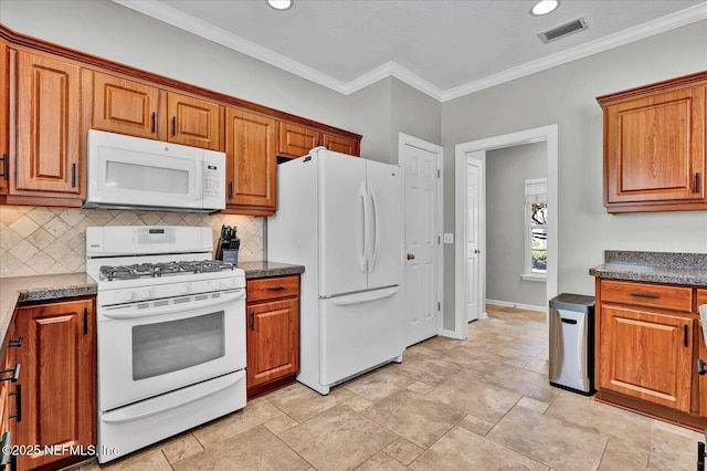 kitchen featuring brown cabinetry, visible vents, white appliances, and tasteful backsplash