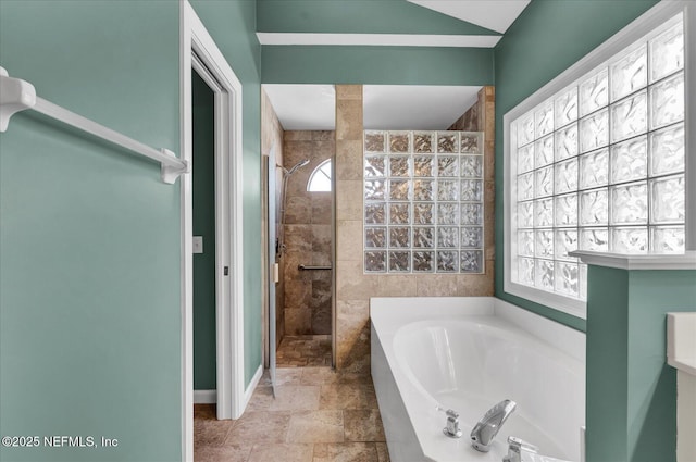 bathroom featuring a bath and tiled shower