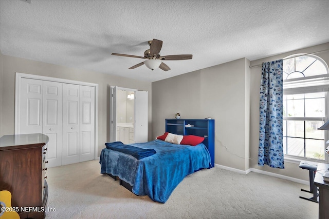 bedroom with a ceiling fan, a textured ceiling, a closet, carpet floors, and baseboards