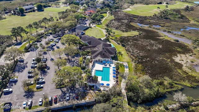 drone / aerial view featuring view of golf course and a water view