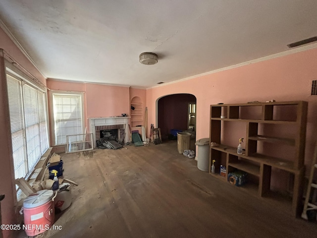 living room featuring visible vents, arched walkways, wood finished floors, crown molding, and a fireplace