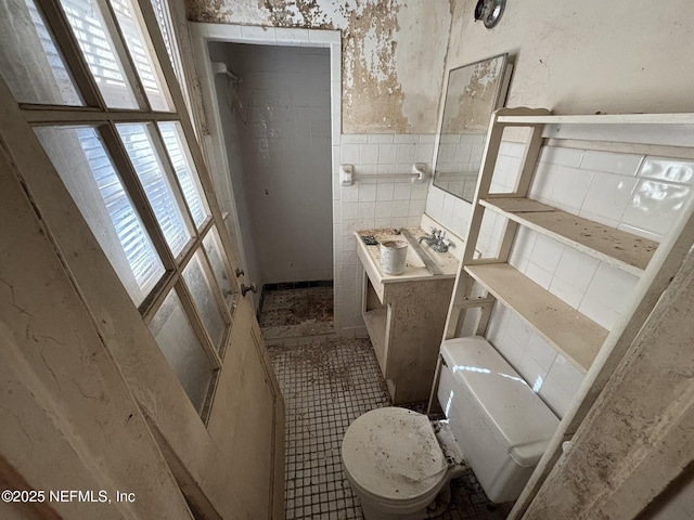 full bathroom featuring tile patterned flooring, toilet, a wainscoted wall, vanity, and tile walls