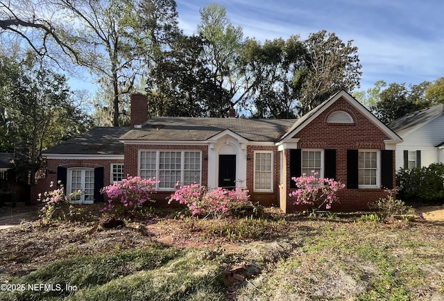 single story home with brick siding and a chimney