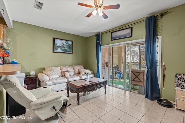 living room with light tile patterned floors, visible vents, and a ceiling fan