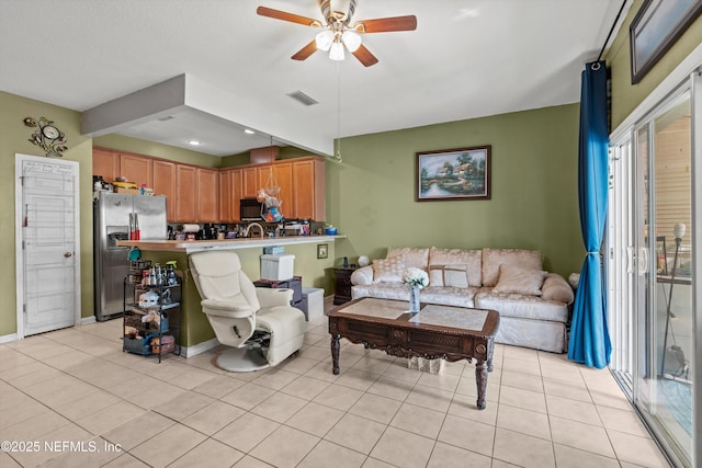 living room with visible vents, ceiling fan, baseboards, and light tile patterned flooring