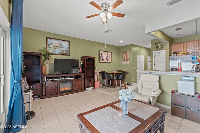 living room with light tile patterned floors, ceiling fan, and visible vents