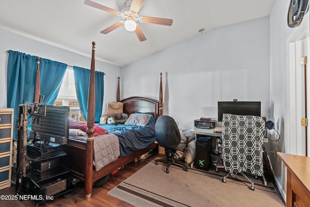 bedroom with ceiling fan, vaulted ceiling, and wood finished floors