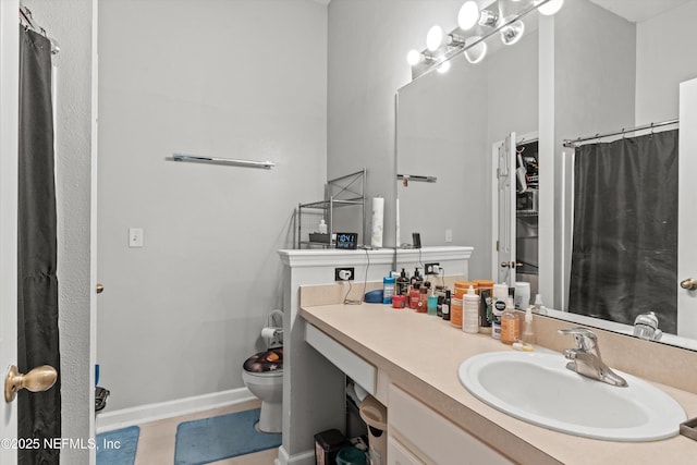 full bathroom featuring baseboards, vanity, and toilet