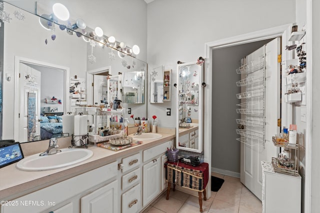 ensuite bathroom with ensuite bathroom, double vanity, a sink, and tile patterned floors