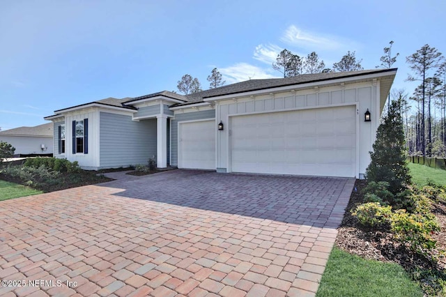 view of front facade featuring an attached garage, decorative driveway, and board and batten siding