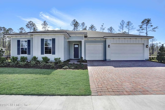 view of front of home featuring decorative driveway, a front lawn, board and batten siding, and an attached garage