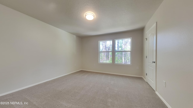 unfurnished room featuring a textured ceiling, baseboards, and carpet flooring