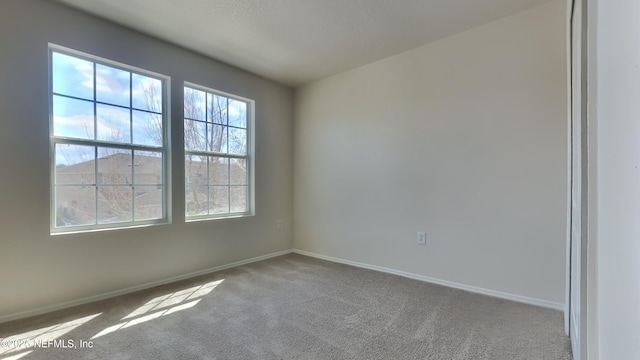 spare room with carpet floors and baseboards