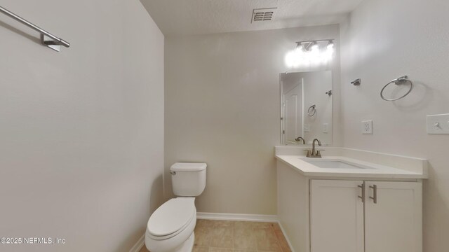 bathroom featuring visible vents, toilet, vanity, tile patterned flooring, and baseboards