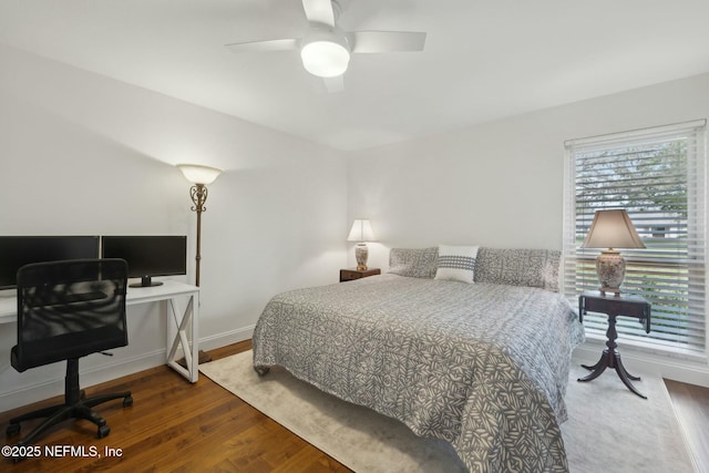 bedroom with ceiling fan, baseboards, and wood finished floors