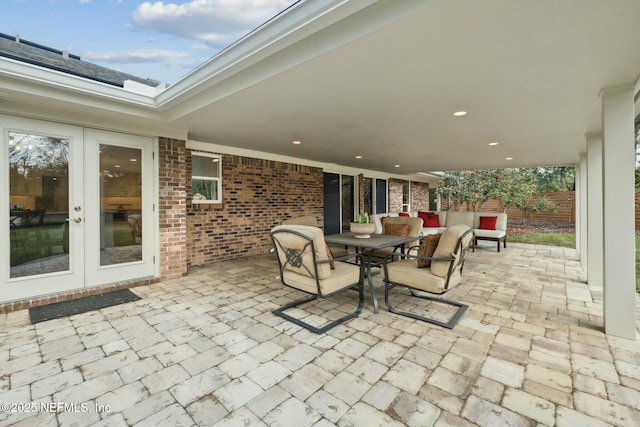 view of patio with outdoor dining space, french doors, and fence