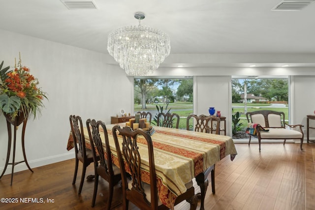 dining space with visible vents, a notable chandelier, a healthy amount of sunlight, and wood finished floors