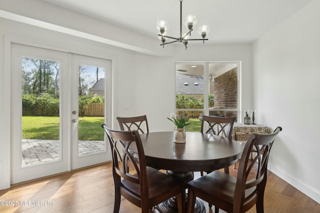 dining room featuring a chandelier, french doors, baseboards, and wood finished floors