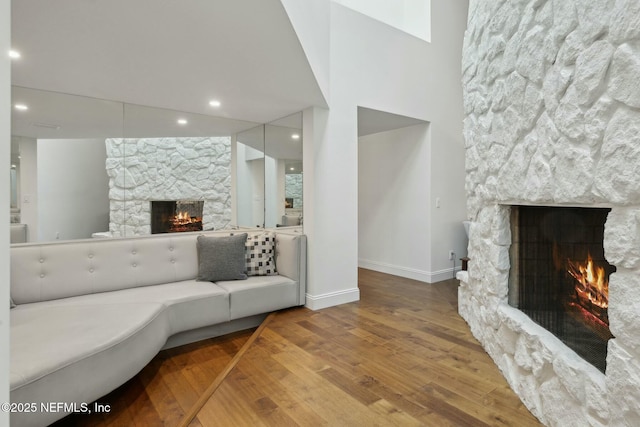 living area with recessed lighting, a fireplace, baseboards, and wood finished floors