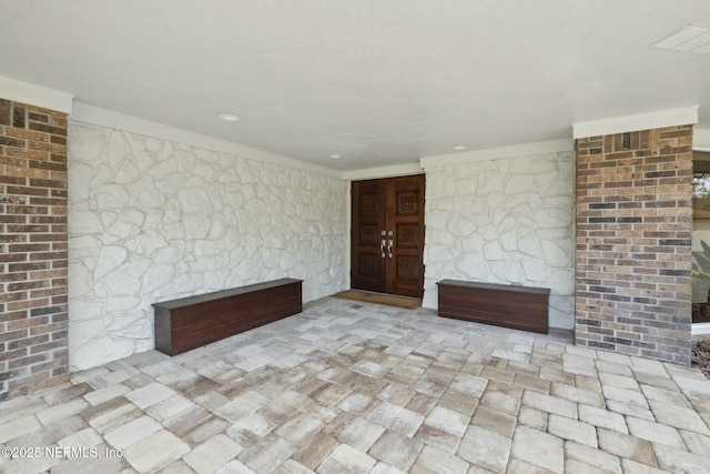 unfurnished living room with crown molding