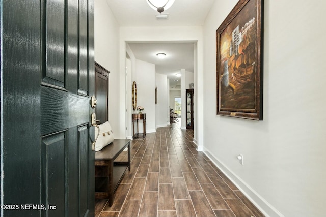 hall featuring baseboards and wood tiled floor