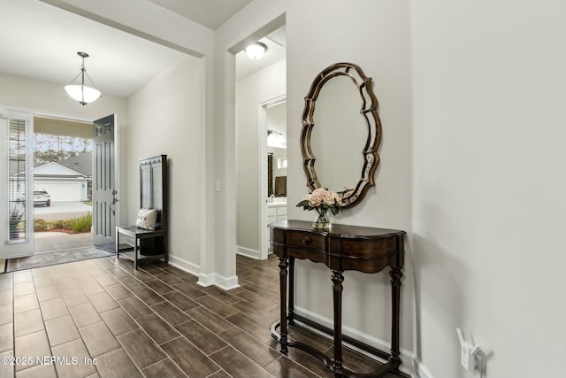 foyer featuring baseboards and dark wood finished floors