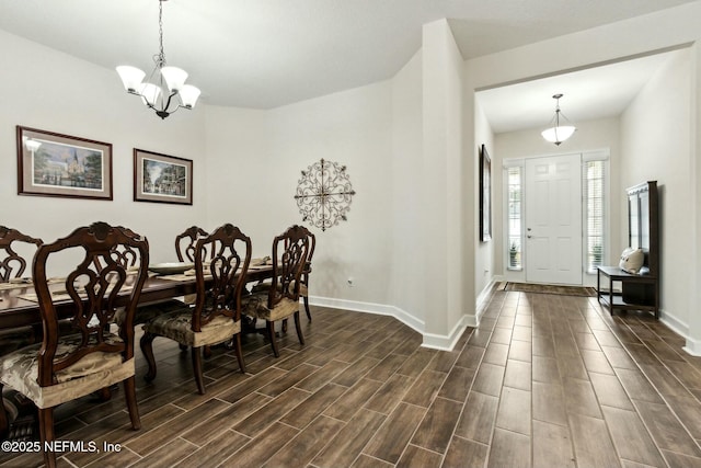 dining area with baseboards, wood finish floors, and an inviting chandelier