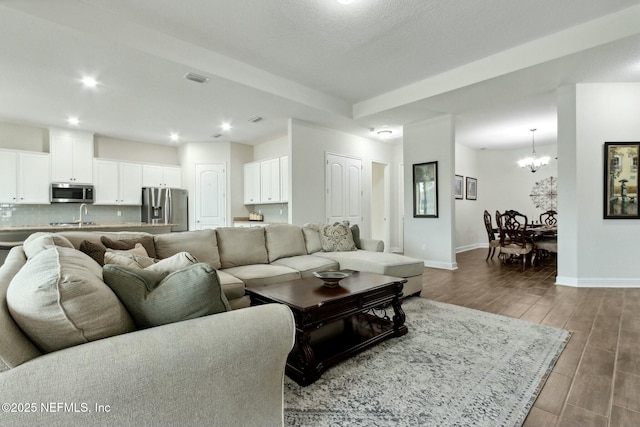 living room featuring recessed lighting, visible vents, an inviting chandelier, wood tiled floor, and baseboards