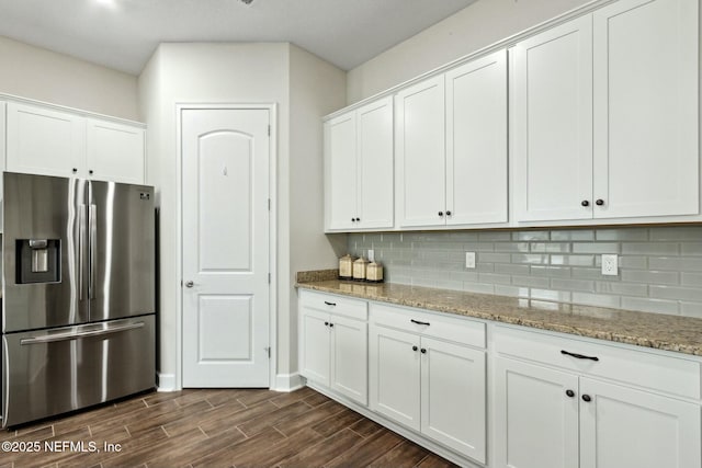 kitchen featuring light stone counters, white cabinets, stainless steel fridge with ice dispenser, wood tiled floor, and tasteful backsplash