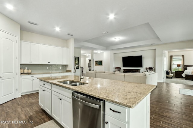 kitchen featuring a sink, open floor plan, stainless steel dishwasher, decorative backsplash, and wood tiled floor